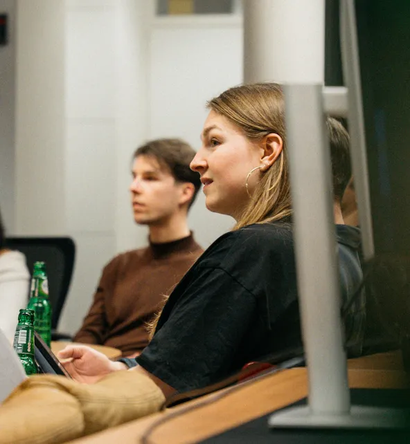 Een collega van Dutch Coding Company luistert aandachtig naar een presentatie over technologie