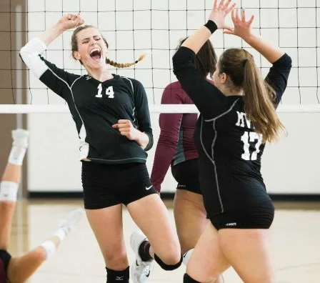 Volleybalspeelsters juichen tijdens een wedstrijd