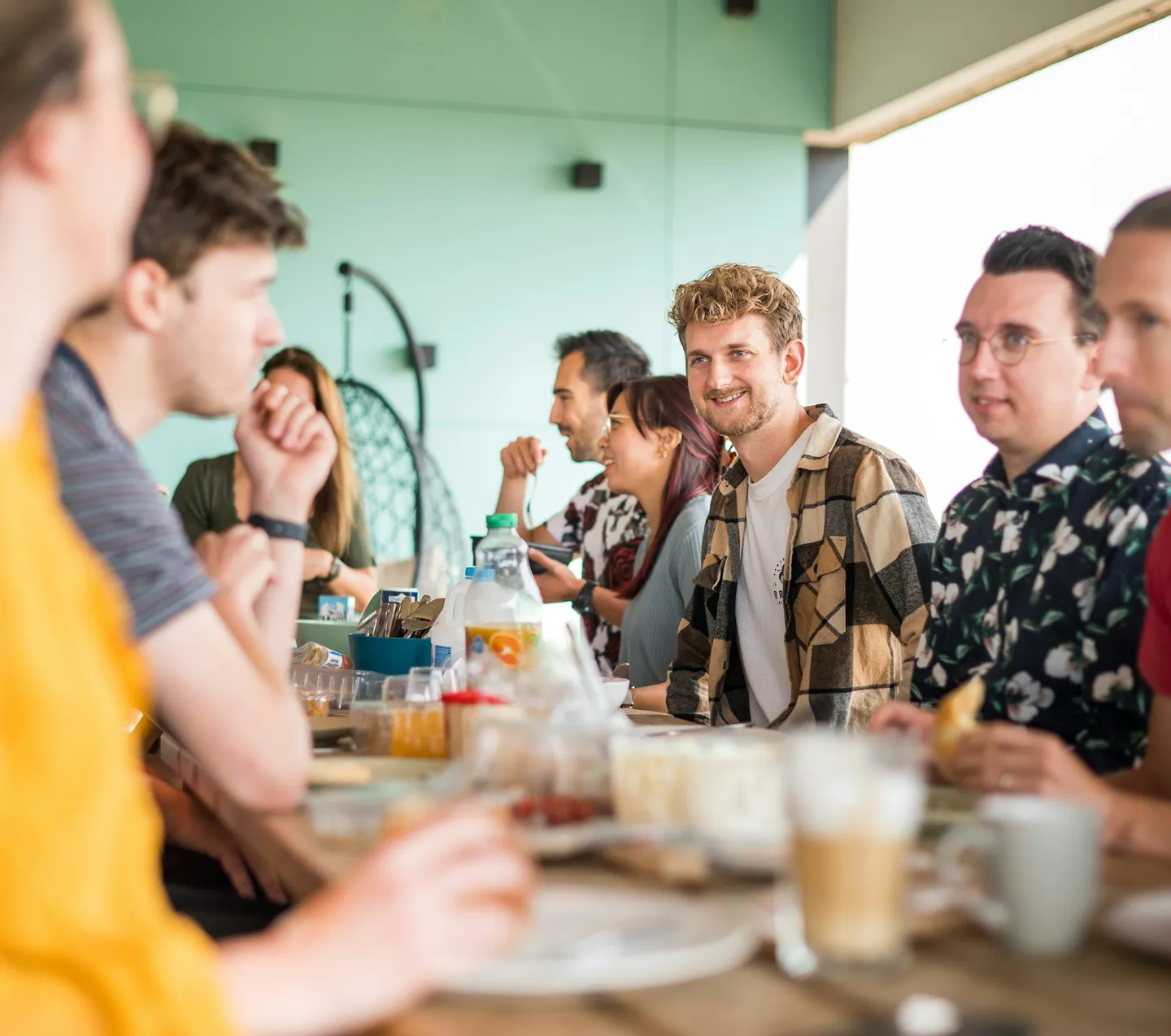 Colleagues talking at a long table with food and drinks