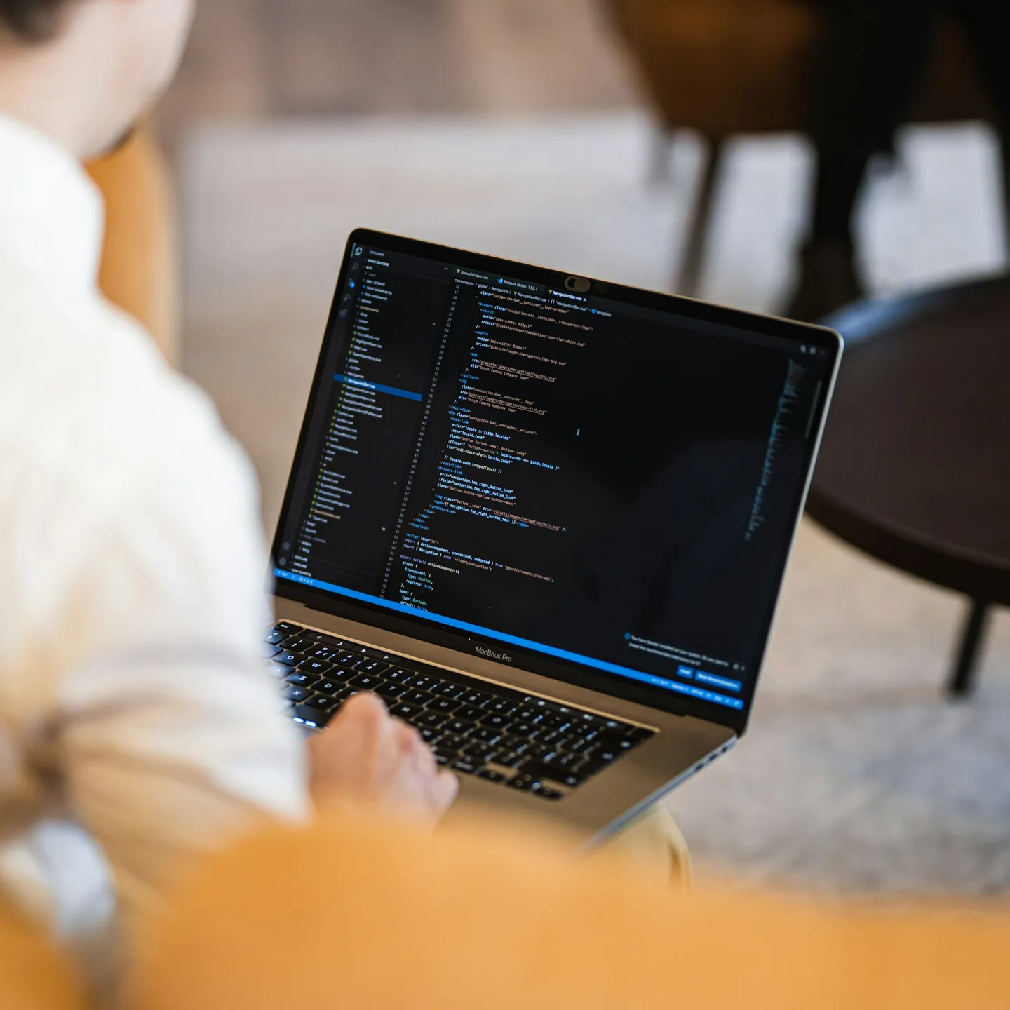 Someone working on a laptop with code on the screen