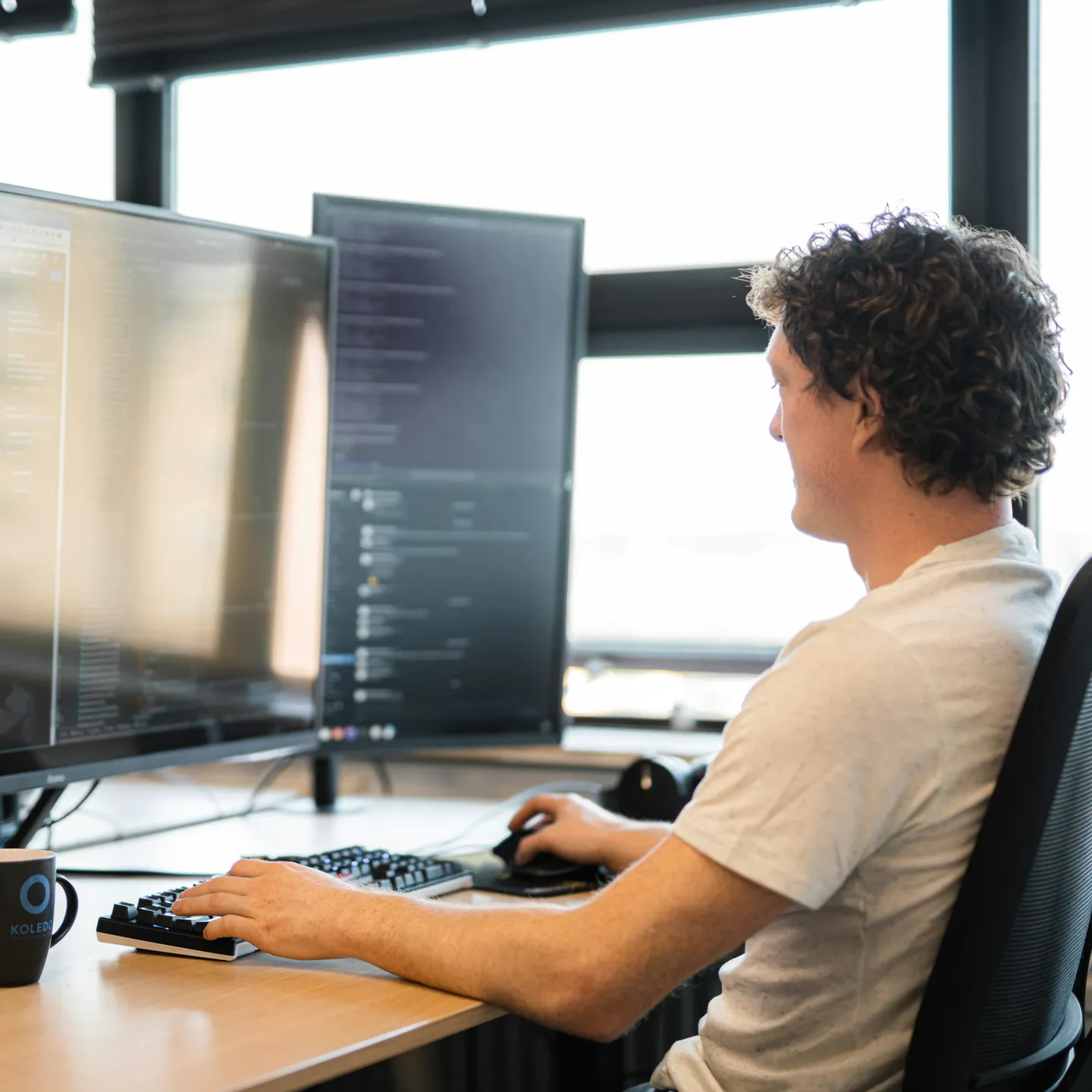 A developer at a desk with two monitors