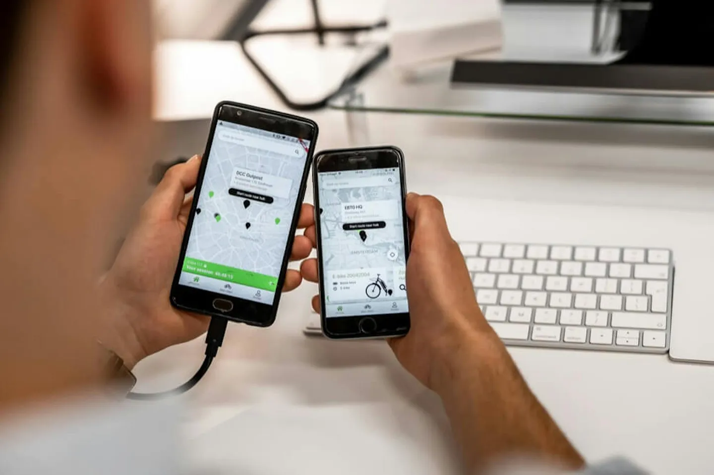 Iemand houdt twee smartphones vast met een app met een kaart op het scherm