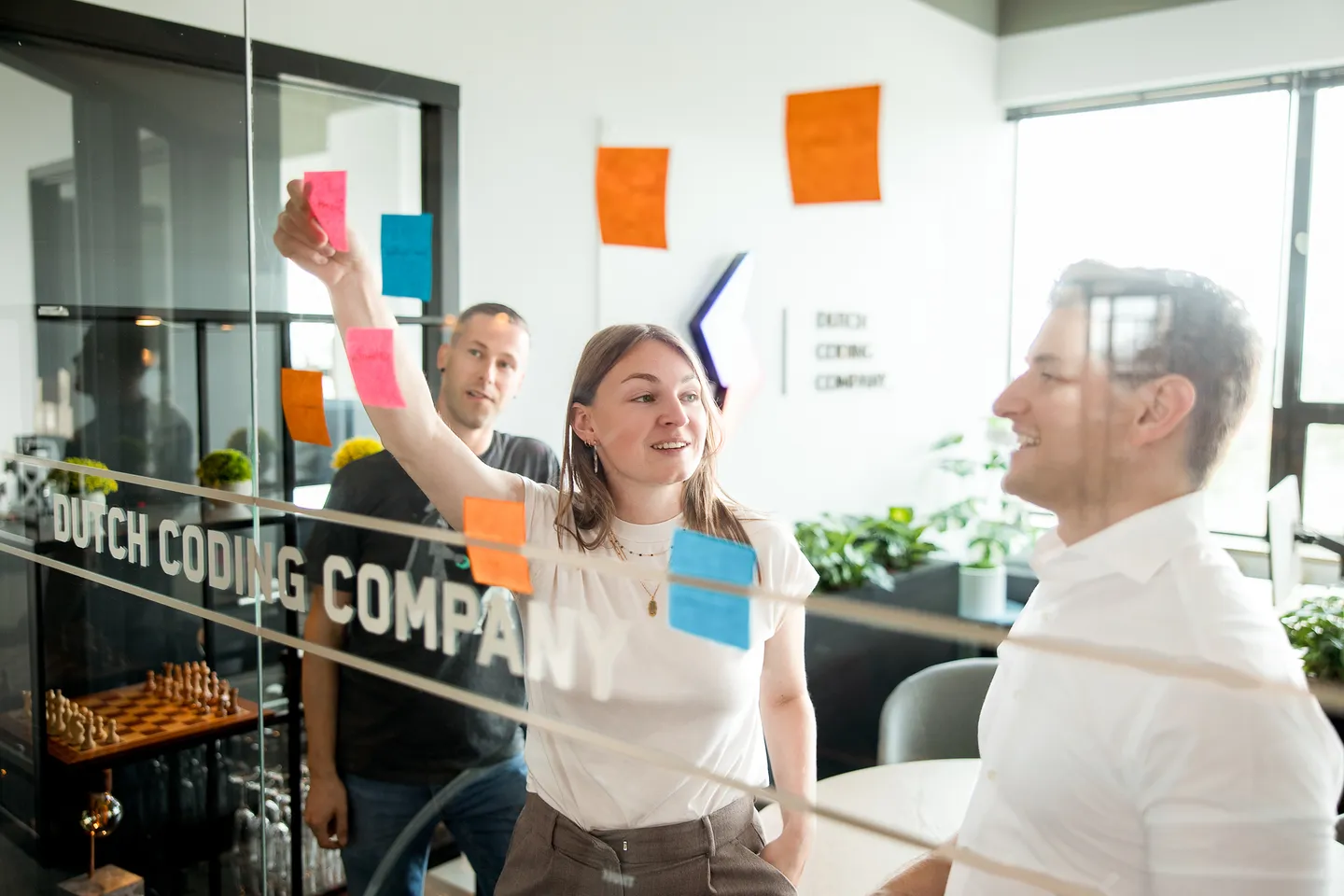 Mensen die post-its op het glas plakken