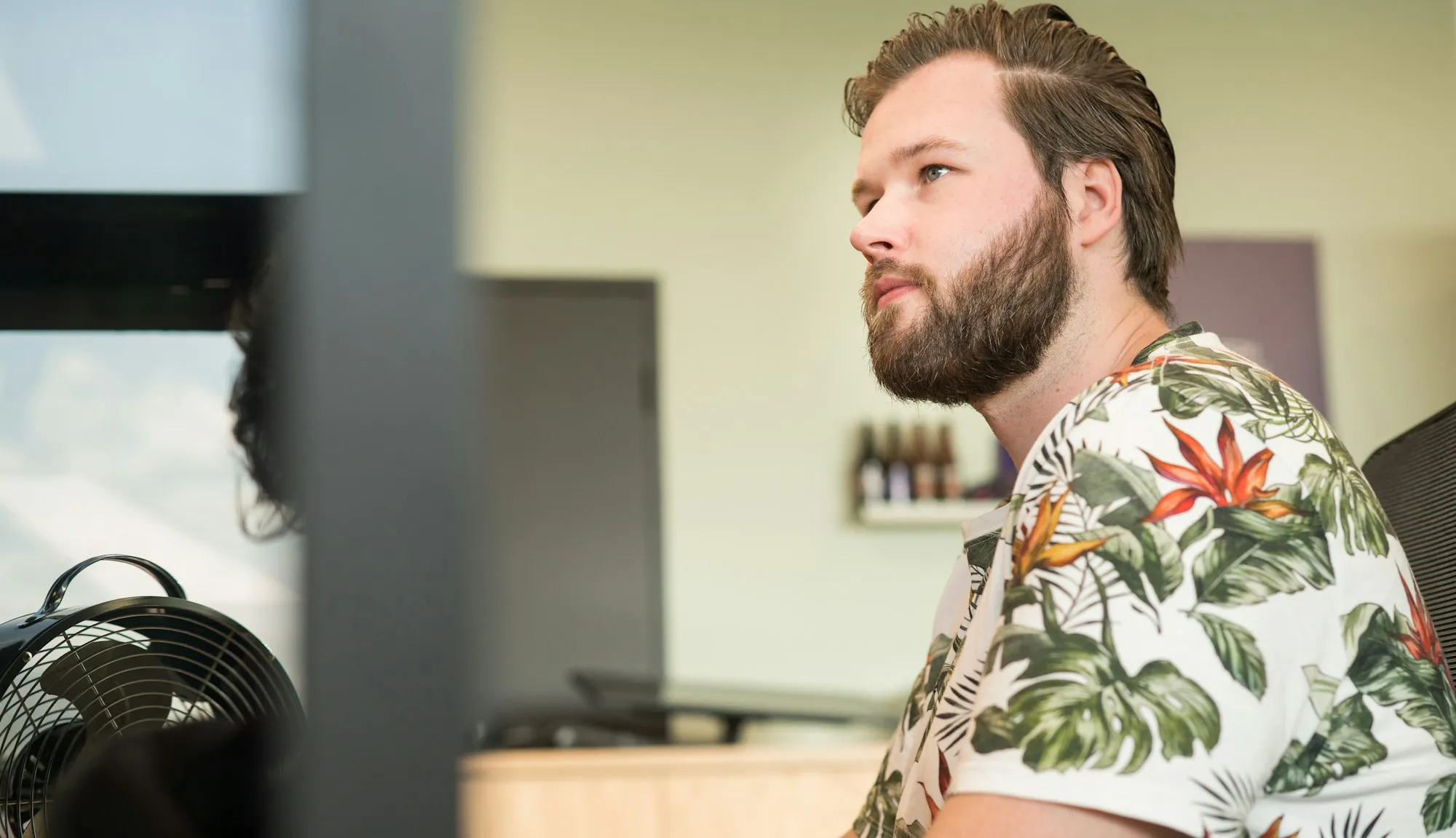A bearded man working in an office