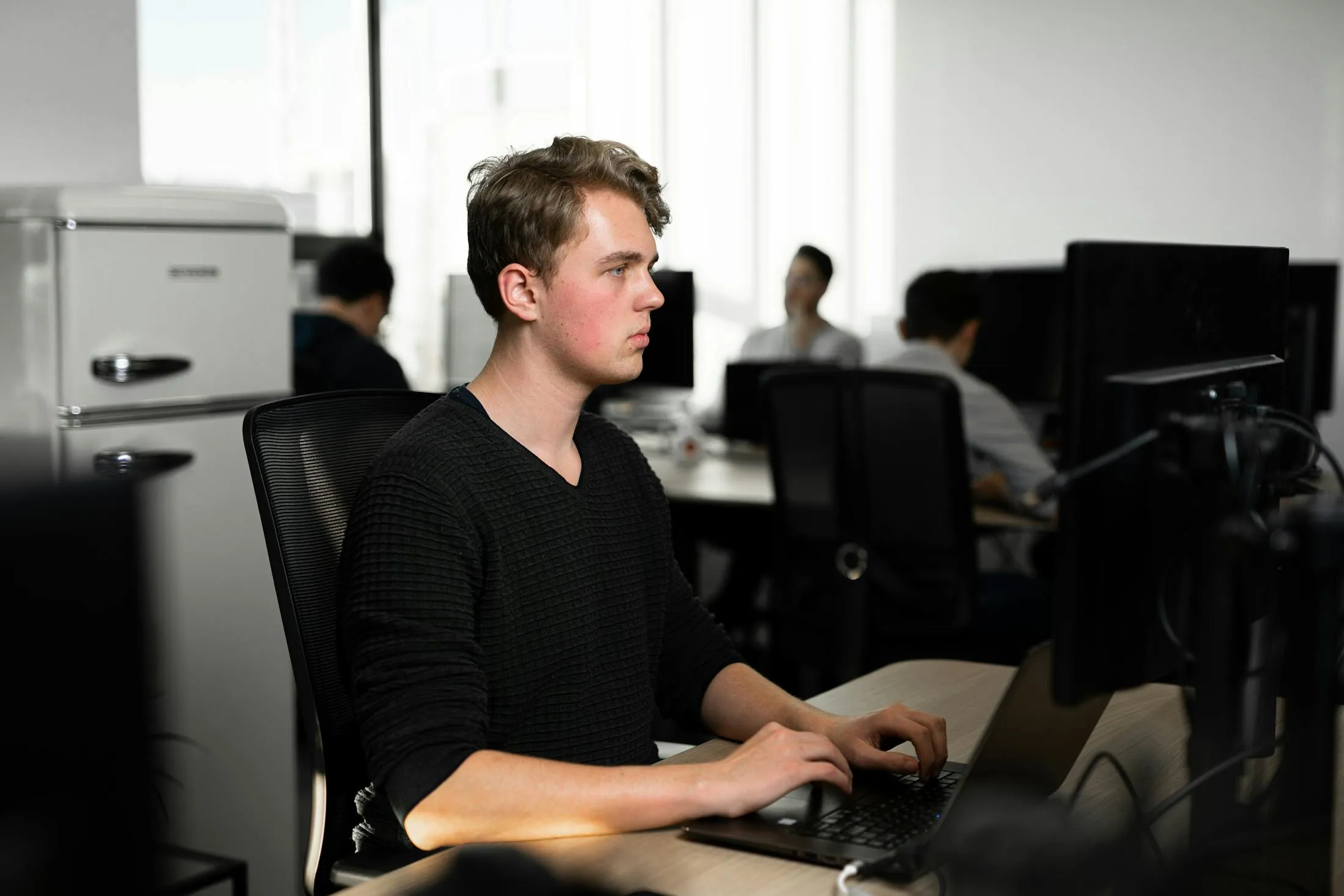 Een developer aan het werk achter een laptop op kantoor