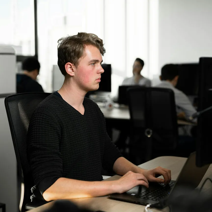 Een developer aan het werk achter een laptop op kantoor