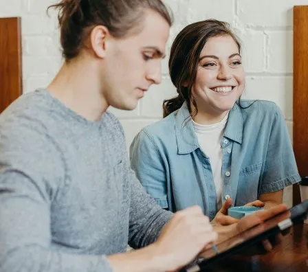 Een man en een vrouw kijken samen naar een tablet