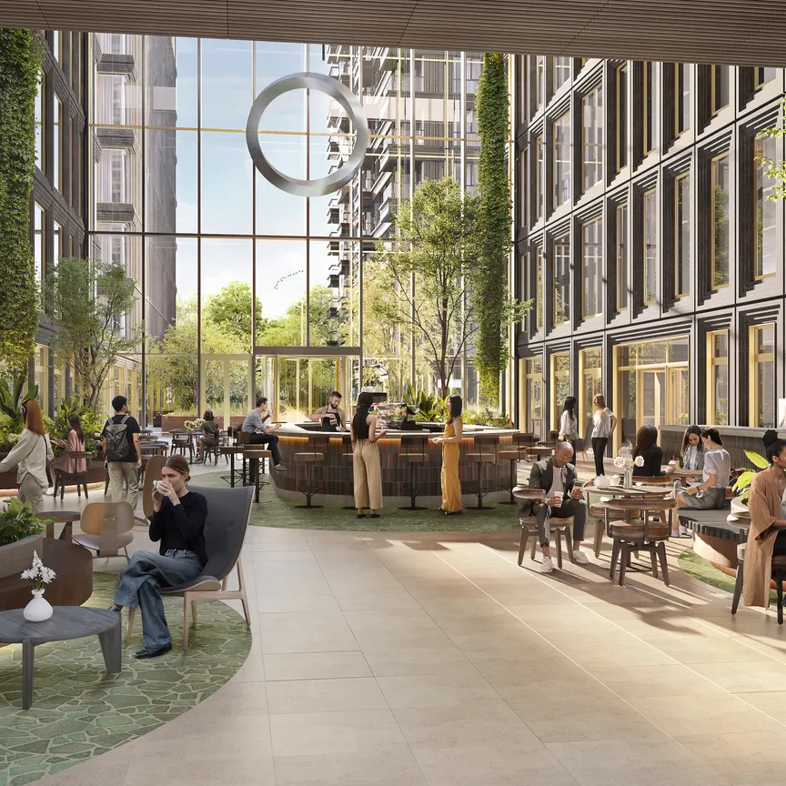 Impression of the EDGE Eindhoven atrium, with greenery, a coffee bar and seating